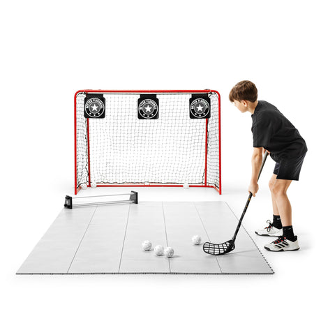 Floorball player running with the ball on a long strip of training tiles