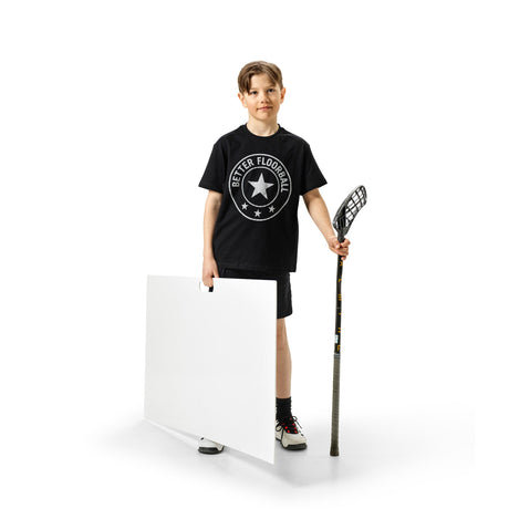 Floorball player practising shots from a shooting pad at home