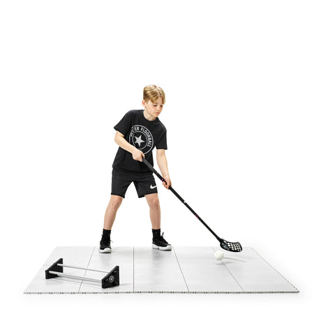 Floorball player on training tiles with stick in a low athletic stance