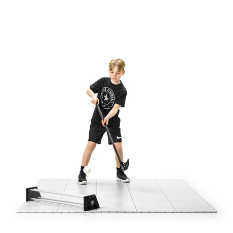 Floorball player doing stickhandling drills on tiles with a passer nearby
